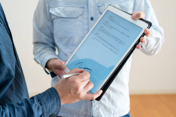 アジア人男性がタブレットでデジタル契約を締結、クローズアップ - 書類変更 ストックフォトと画像