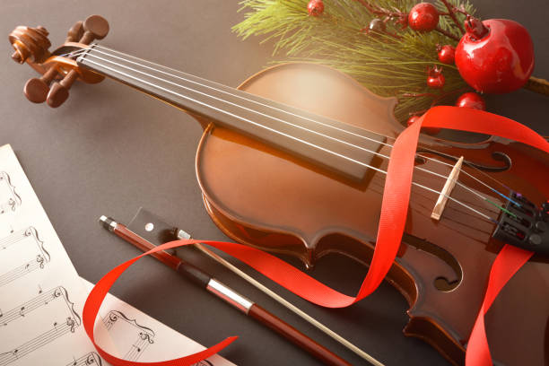 istock Violin with bow and sheet music on black background golden 1193524062