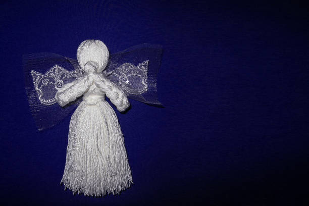 Adorable baby girl dressed in Angel costume sitting on a fluffy blanket and looking over shoulder.