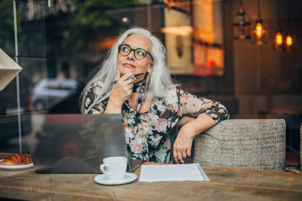 istock Mature lady author sitting in cafe alone 1193528768