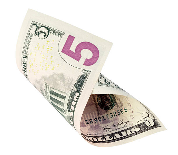 Five dollar note curled up on itself stock photo