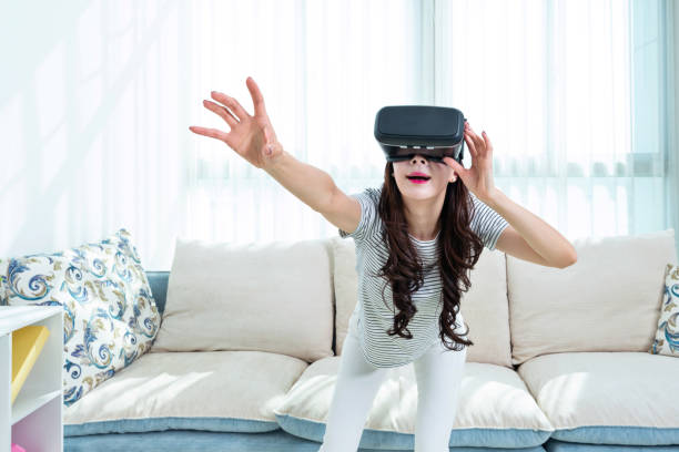 istock Woman wearing virtual reality simulator at home 1193533829