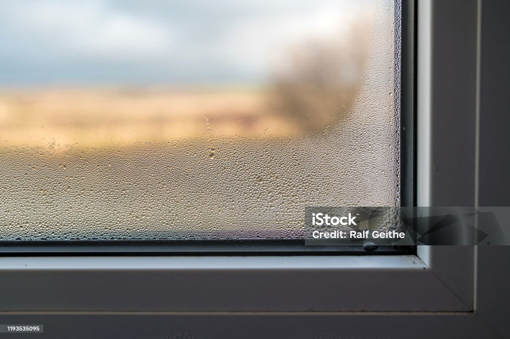 Mold formation through fogged window pane due to poor ventilation of the room High humidity ensures condensation and mold Window Stock Photo