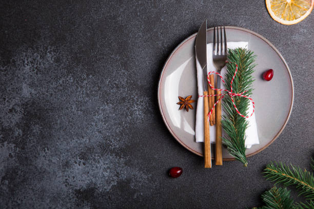istock Christmas table with a plate, fork, knife, Christmas tree branches and Christmas decorations. top view, copy space 1193536250