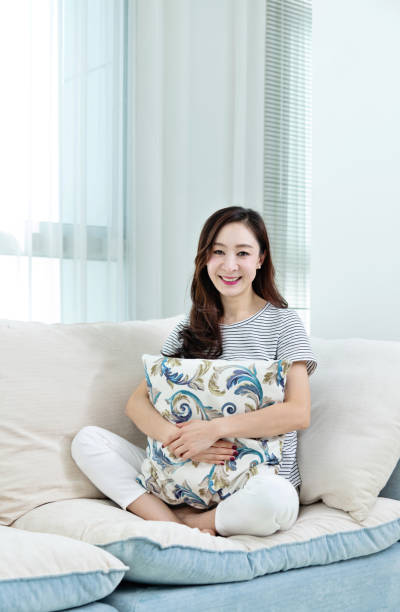 istock Smiling woman sitting on sofa 1193536601