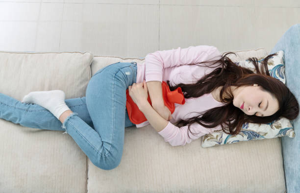 istock Woman lying on sofa with hot water bottle 1193538624