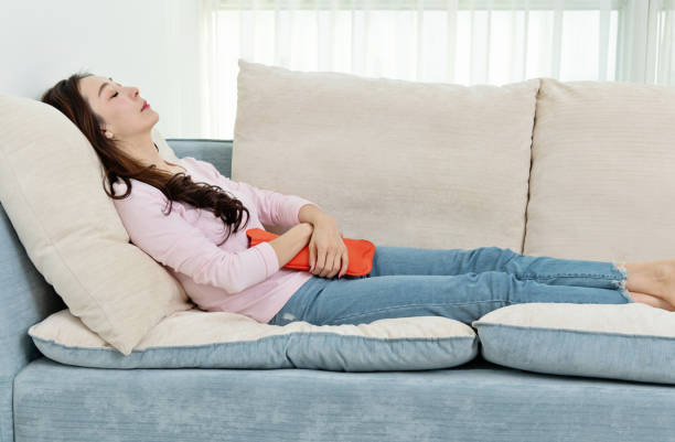 istock Woman lying on sofa with hot water bottle 1193538772