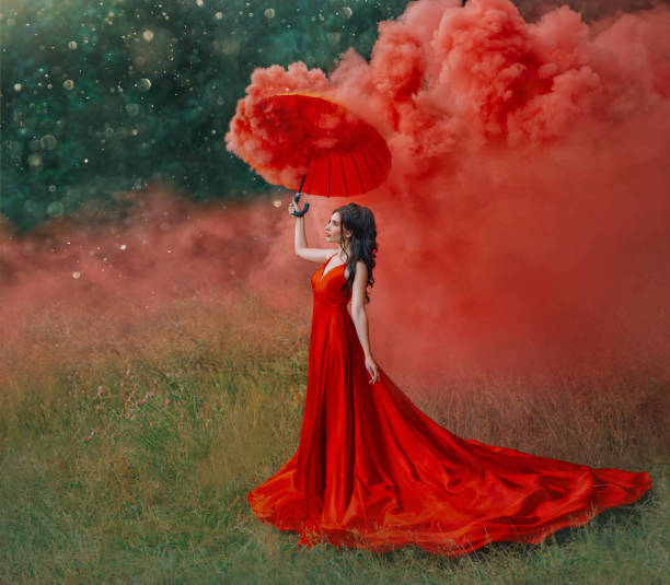 femme dans le train long rouge de robe de soie avec le parapluie. photographie de design d'art. - fairy forest women magic photos et images de collection