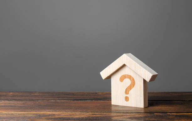 istock Question mark on a wooden house. Cost estimate. Solving housing problems, deciding to buy or rent real estate. Search for options, choice of type of residential buildings. Property valuation 1193540582