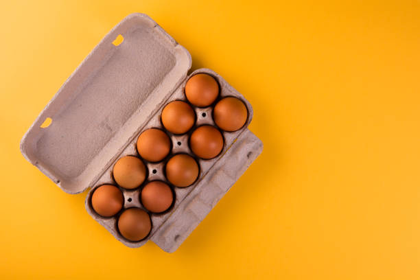 istock raw eggs in a carton on a yellow background 1193542656