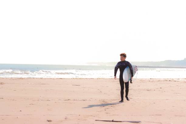 istock Asian surfer at the beach 1193544452