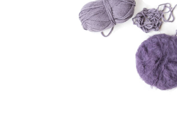 Purple woolen yarn balls on the white background. Isolated subjects. Copy space. Place for text and design. Top view. Flat layout.