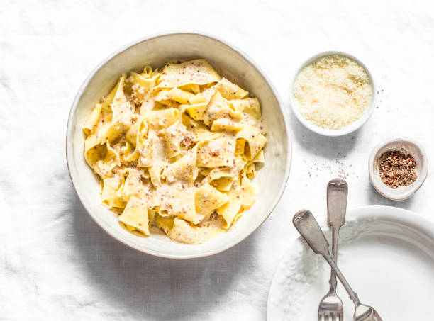 Fresh pappardelle with walnuts mascarpone cheese cream sauce. Delicious lunch in mediterranean style on a light background, top view Fresh pappardelle with walnuts mascarpone cheese cream sauce. Delicious lunch in mediterranean style on a light background, top view white cheese stock pictures, royalty-free photos & images