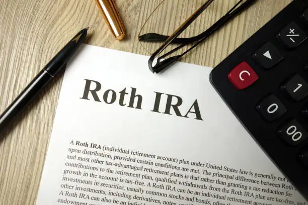 Photo of Roth IRA mockup with calculator pen and glasses