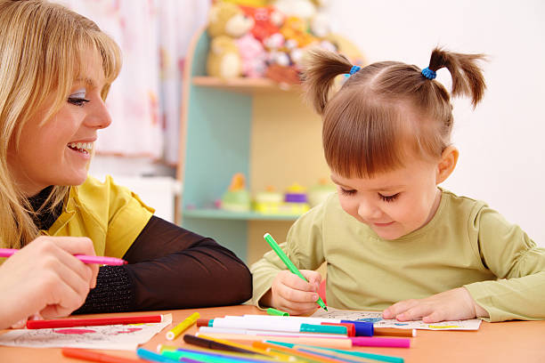 istock Teacher with child in preschool 119354779