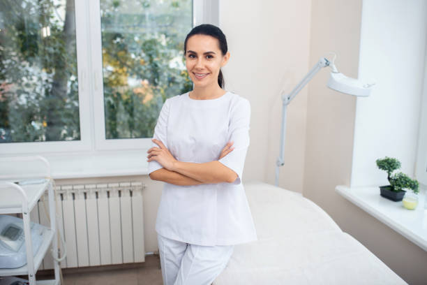 istock Dark-eyed plastic surgeon wearing white uniform standing in clinic 1193548507