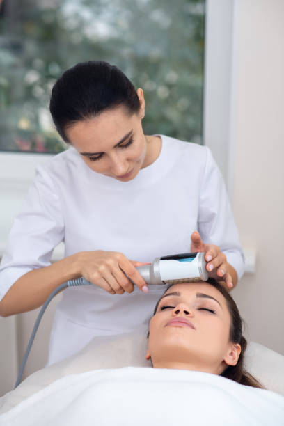 istock Massage specialist wearing white uniform standing near patient 1193548565