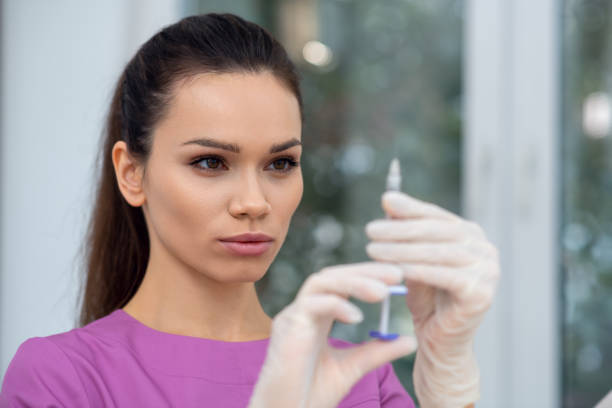 istock Cosmetologist looking at syringe with beauty injection 1193548650