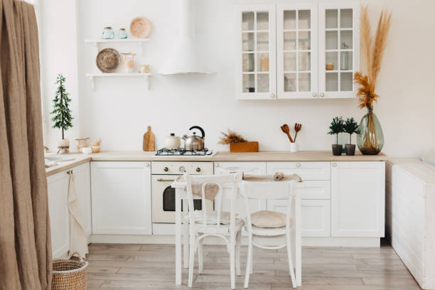 istock Modern new bright kitchen interior with white furniture and a dining table. 1193551783