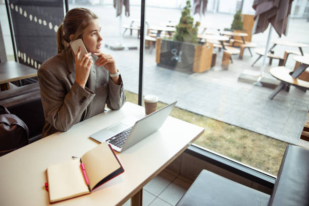 istock Beautiful young woman talking on cellphone in cafe 1193552746