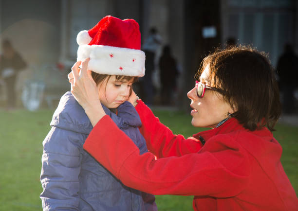 クリスマスシーズン中に悲しい気持ちになる母親の子ども - grief women selective focus outdoors ストックフォトと画像