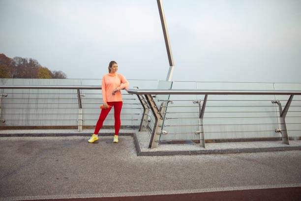 istock Charming sporty woman standing on the bridge 1193552879