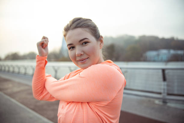 istock Charming young woman doing morning exercise outdoors 1193553139