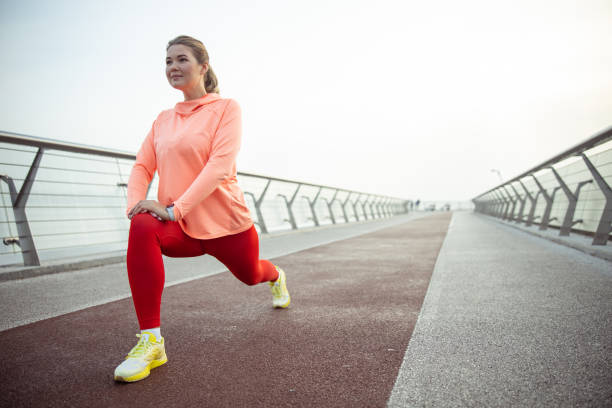 istock Charming sporty lady stretching legs on the bridge 1193553180