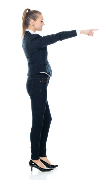 istock Full length / side view / profile view / front view / looking at camera / one person of 20-29 years old adult beautiful brown hair / ponytail caucasian female / young women business person / businesswoman standing who is pointing with hand by side 1193554980