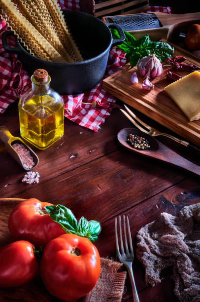 istock Italian pasta and ingredients on rustic pots and wooden table in a kitchen 1193556096