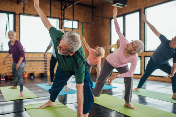 istock Seniors exercising yoga in a group 1193556268
