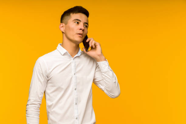 young male asian businessman talking seriously on the phone. - telephone child isolated on white elegance - fotografias e filmes do acervo