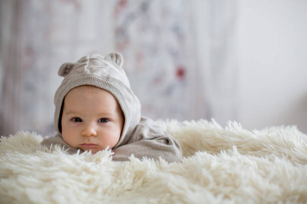 istock Sweet baby boy in bear overall, sleeping in bed with teddy bear 1193563700