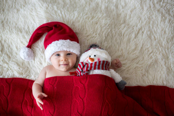 ritratto natalizio del simpatico bambino appena nato, con indosso il cappello di babbo natale - baby santa claus christmas sleeping foto e immagini stock