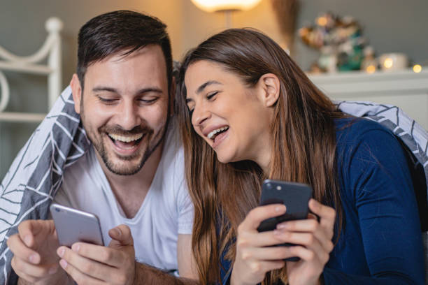 istock Young couple in bed using smart phone 1193564771