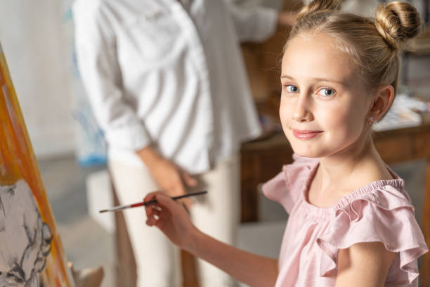 istock Nice small girl posing for camera in art room 1193565298