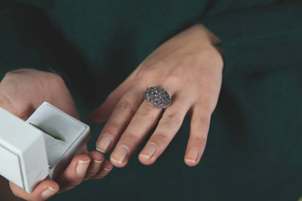 istock woman hand holding ring with box 1193566338
