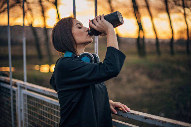 istock Young woman is drinking water after running 1193567490