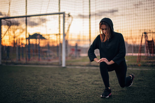 Beautiful young woman is sports clothing is stretching.