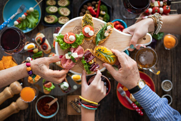 tapas für viele menschen in den händen anbieten und servieren - antipasto stock-fotos und bilder