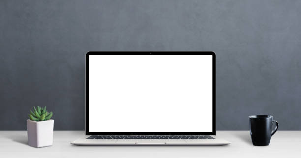 istock Modern laptop computer on work desk with isolated screen for mockup, app or web site promotion. Clean desk with cup of coffee and plant 1193570272