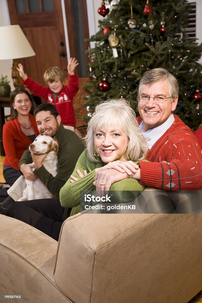 Senior pareja con su familia por árbol de navidad - Foto de stock de 30-39 años libre de derechos