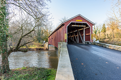 A country road leads to Hunsecker's Covered Bridge spanning Conestoga Creek in Lancaster County, Pennsylvania.