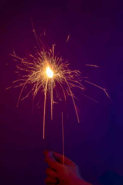 istock sparkler in hand on a neon background. Long exposure 1193574219