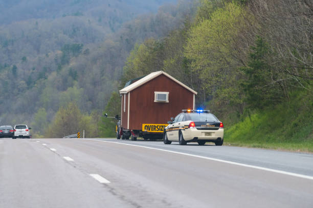 Tennessee highway road and police vehicle stopping oversize load truck for tiny house Erwin, USA - April 19, 2018: Smoky Mountains in Tennessee highway road sign and police vehicle stop oversize load tiny house tow truck tennessee road sign stock pictures, royalty-free photos & images