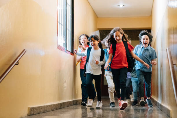 istock Elementary age Students running in school corridors on the last day of school 1193575399