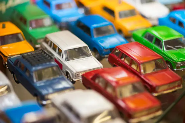 Photo of Big collection of retro car models on the shelf. Miniatures of colorful vintage vehicles in the shop. Selective focus