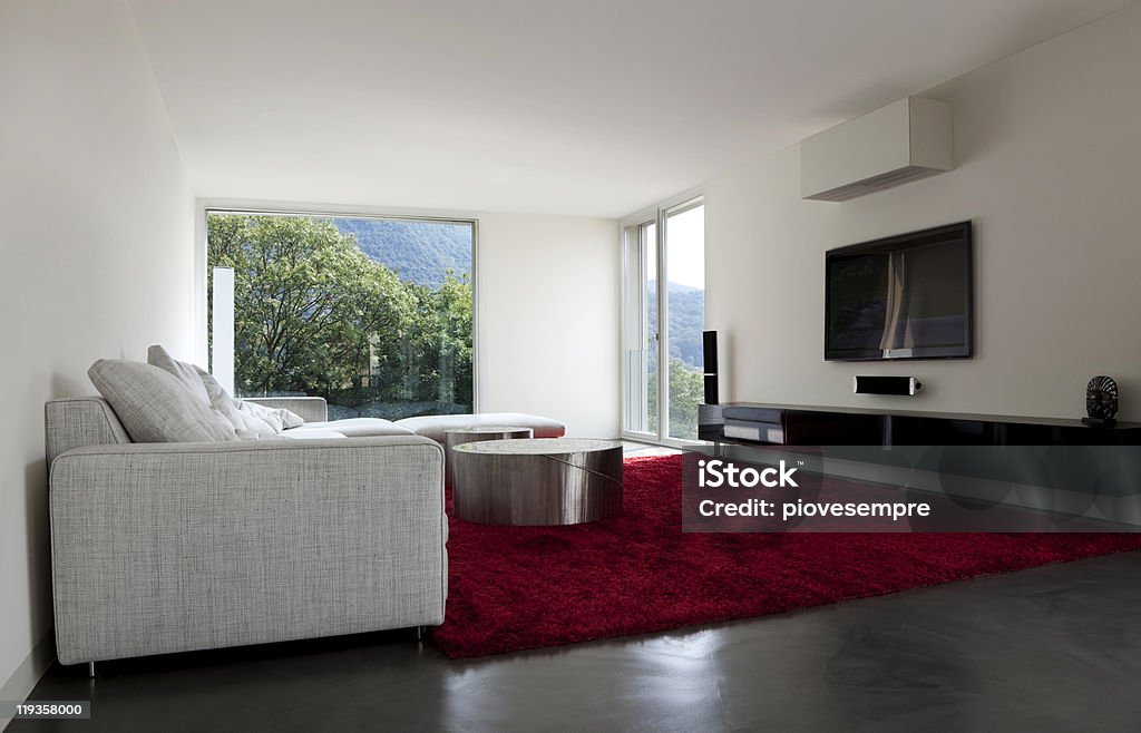 Modern living room with red carpet and green mountain view beautiful new apartment, livingroom http://i705.photobucket.com/albums/ww51/piovesempre/banner_architecture2.jpg Apartment Stock Photo