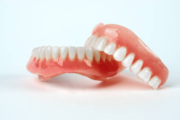 istock Diagnosis prosthetics treatment concept. Artificial teeth and magnifying glass 1193582088