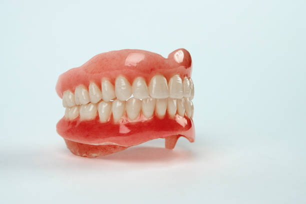 istock Diagnosis prosthetics treatment concept. Artificial teeth and magnifying glass 1193582116